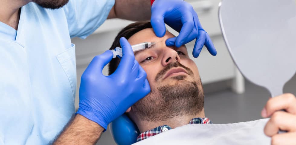 Botox for men administered between man's eyebrows