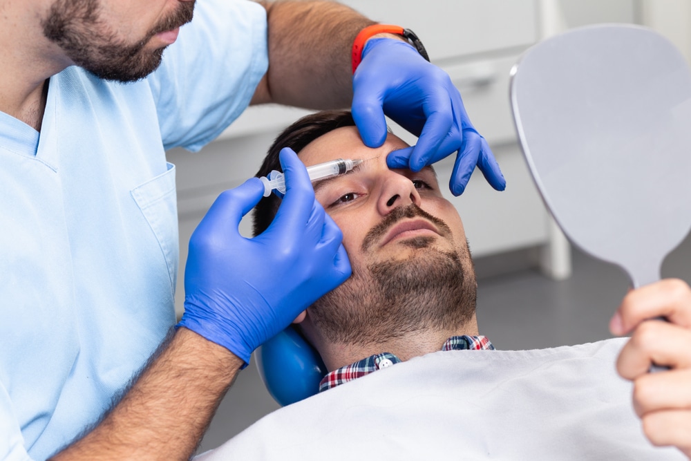 Botox for men administered between man's eyebrows