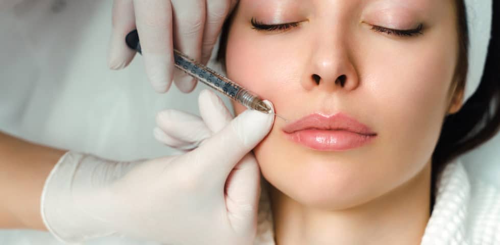 Close up of relaxed woman getting lip injections and getting past whether lip injections hurt