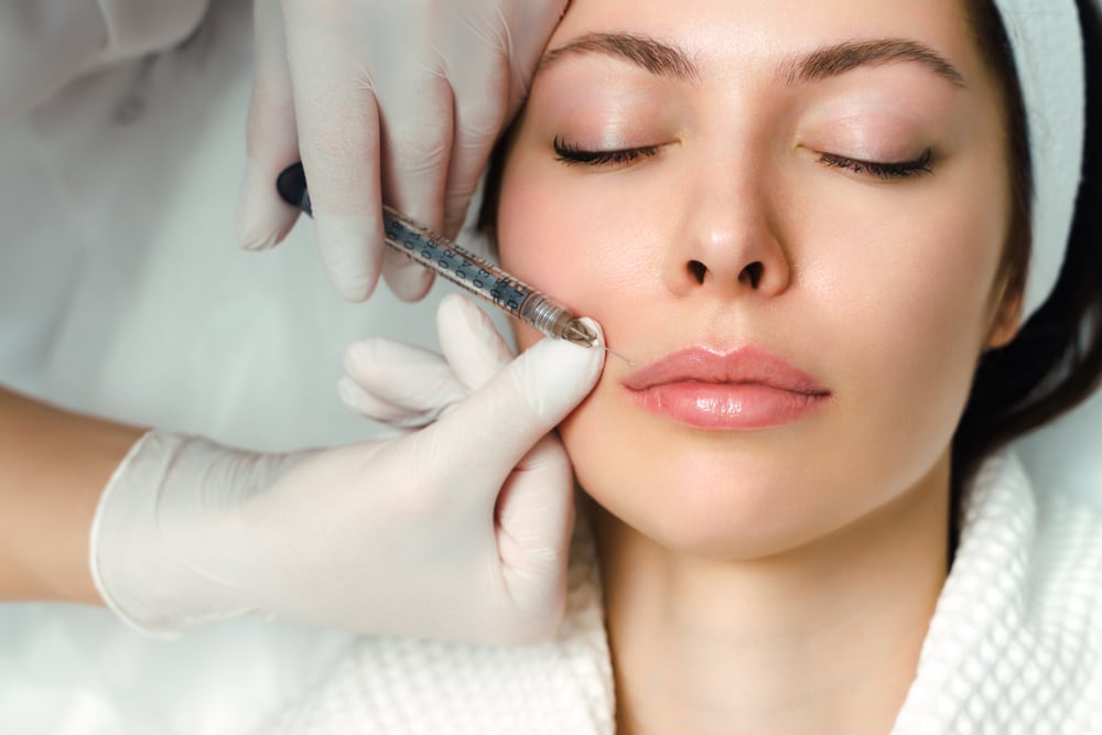 Close up of relaxed woman getting lip injections and getting past whether lip injections hurt